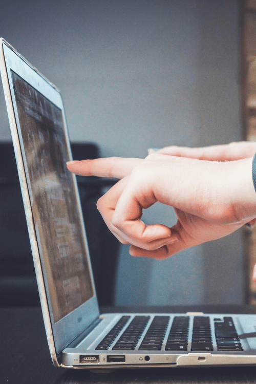 Hand som pekar på laptop skärm
