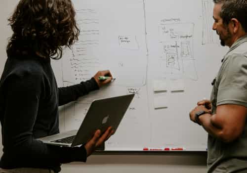 Två personer som arbetar på whiteboard
